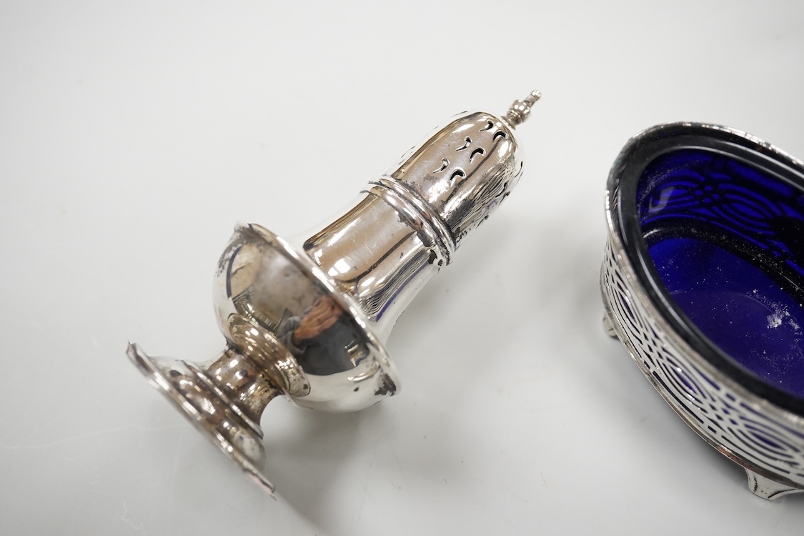 An ornate Edwardian silver oval mustard pot and matching spoon by Barker Brothers, Birmingham, 1902, length, 95mm, together with five other assorted silver condiments including a pair of pierced oval salts with blue glas